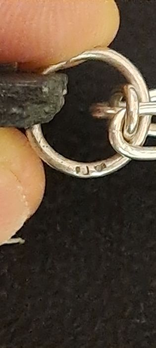 Cordão corrente com pendente em prata contrastada.