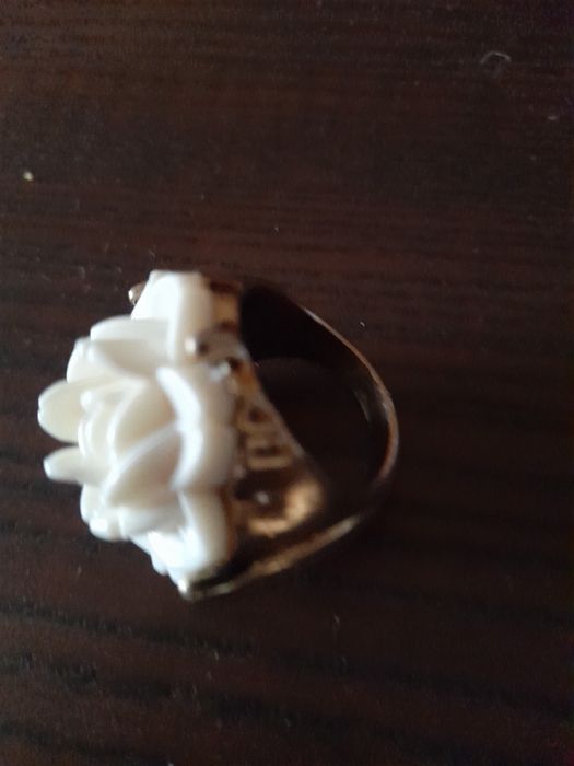 Anel dourado com uma grande flor em branco