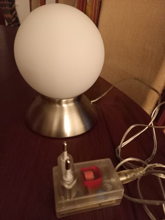 Candeeiro com base em inox e globo branco.