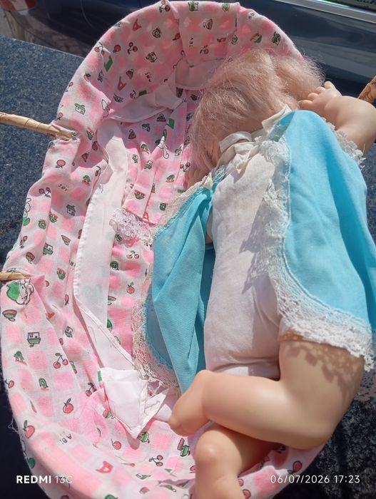 Boneca antiga num berço de vime