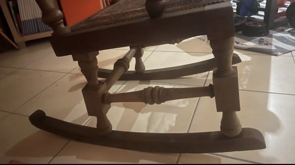 cadeira de balanço de madeira com assento e encosto em couro gravado