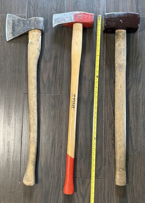 ручні інструменти для роботи з деревом та будівельних завдань: класична сокира, спеціалізований колун-молот STIHL та масивна кувалда.