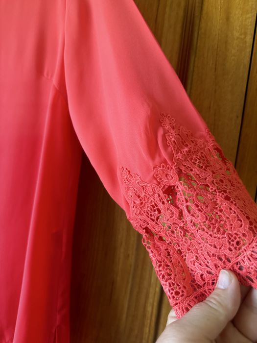 Blusa de senhora, na cor coral. Veste um L.
