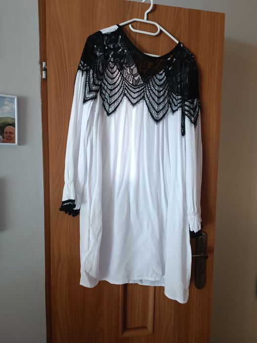 Tunika biala z czarnym ażurowym wykończeniem.