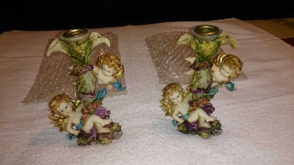2 castiçais (para colocar velas) com anjos decorativos