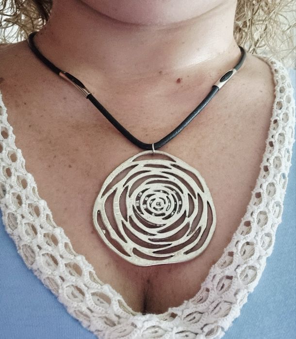 Colar preto com flor em prateado. Tem extensor