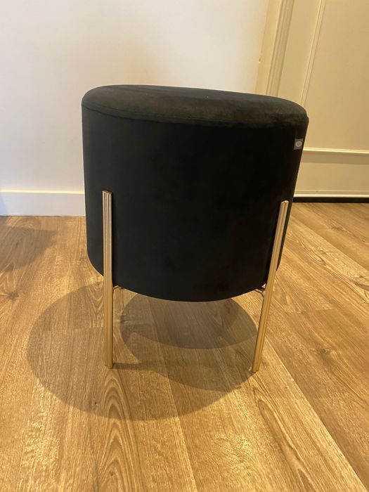 Puff preto com pernas em metal dourado, dimensões 40x34 cm