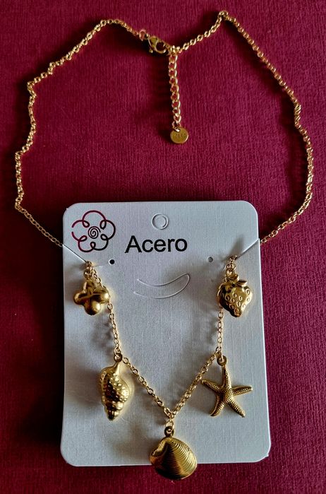 Colar dourado, em aço, com 5 pingentes diferentes. Tem extensor.