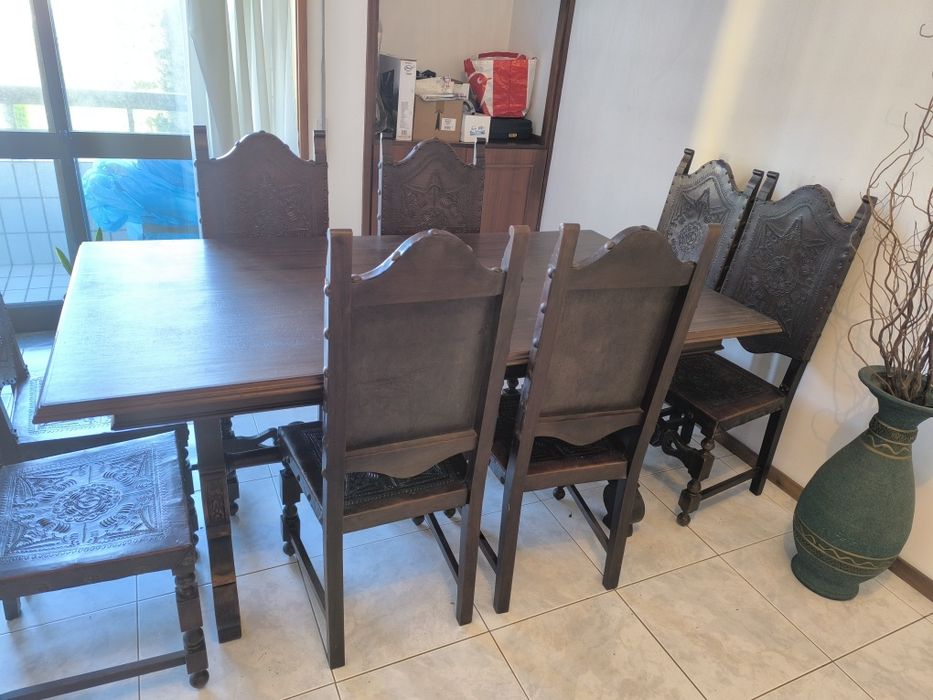 Mesa de madeira e cadeiras em couro
