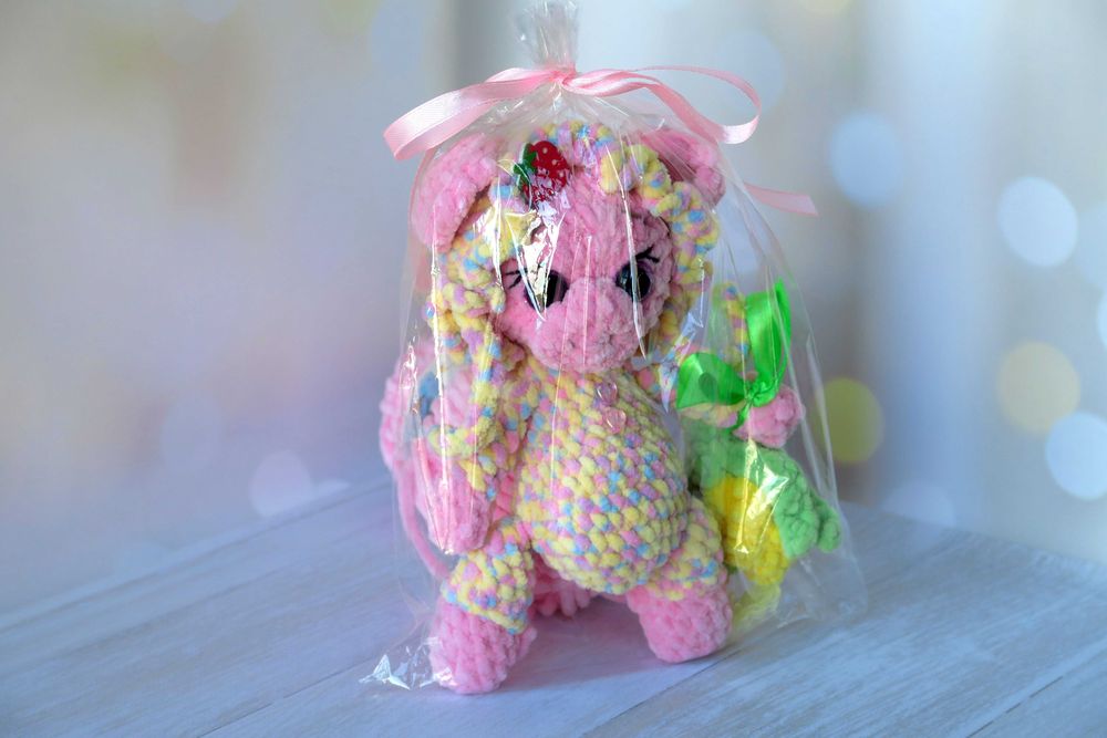 В'язана кольорова свинка в чепчику та з кукурудзою