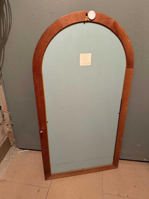 Lustro na ścianę w drewnianej ramie.