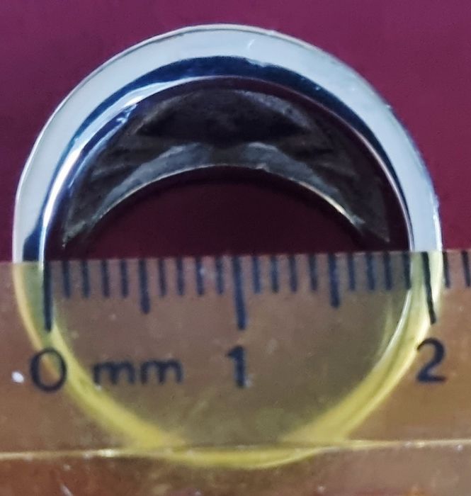 Anel prateado, em aço, com zirconias e uma pedra preta lapidada. T19