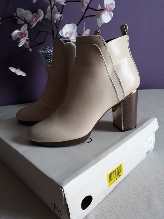 Botki beżowe na słupku.