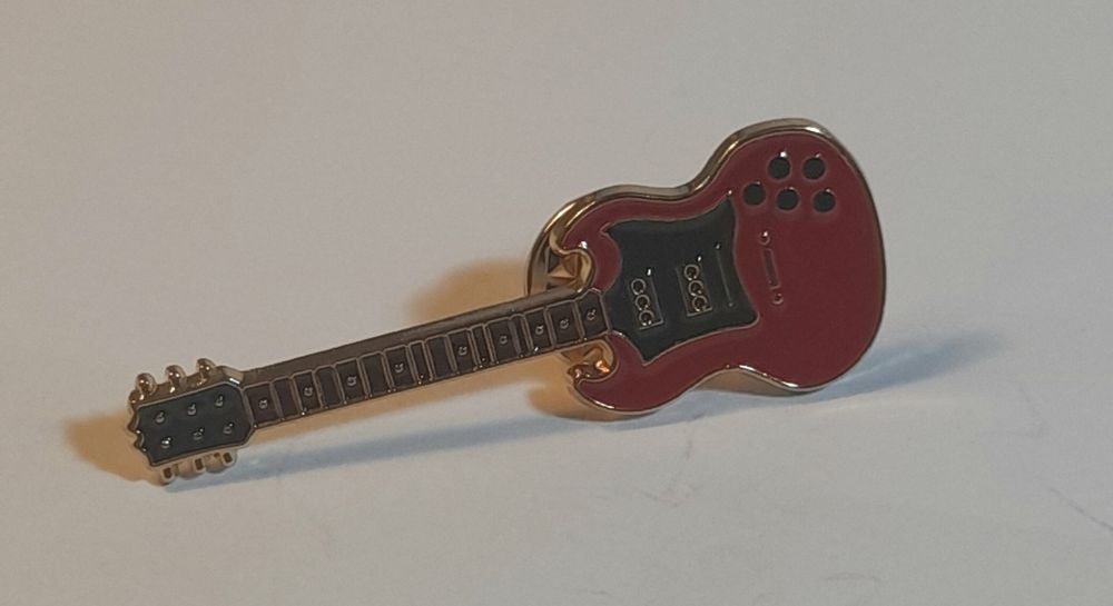 Pin com design de guitarra.
