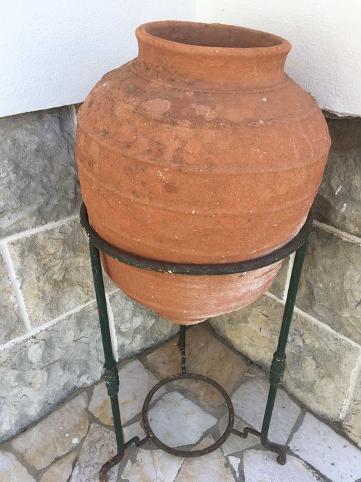 Pote em terracota com base em ferro batido