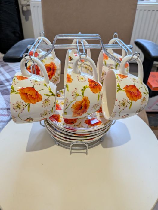 Набір чашок з тарілками на підставці .