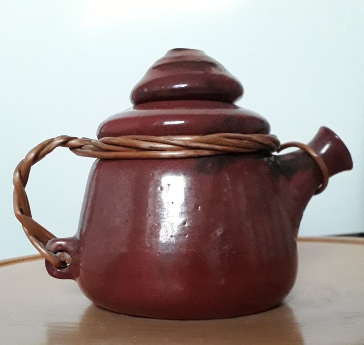 Ceramiczny dzbanek z oplotem wiklinowym.