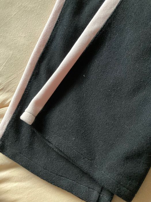 Czarne, damskie polarowe spodnie z lampasem.