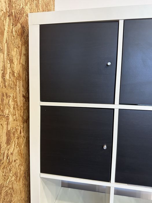 estante branca com portas pretas + caixas azuis em baixo