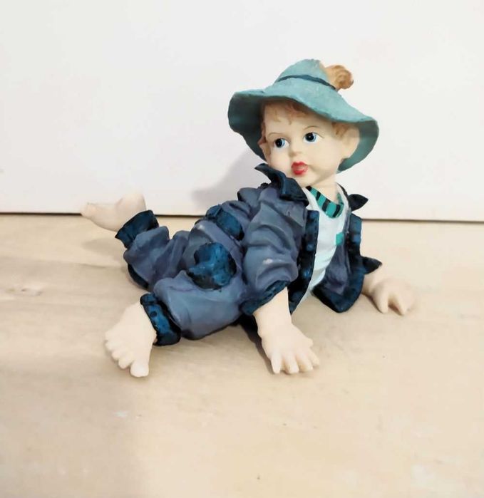 Estatuetas meninos a gatinhar