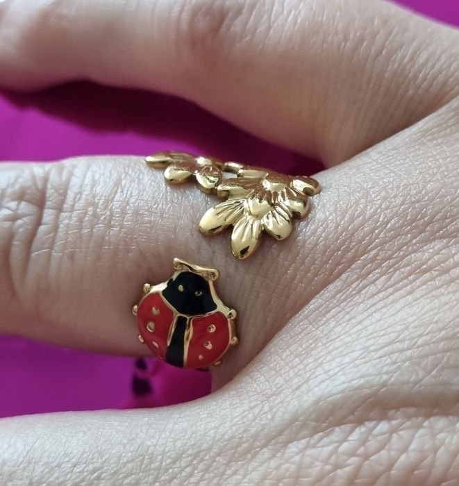 Anel dourado, em aço, com folhas e 1 joaninha. Ajustável