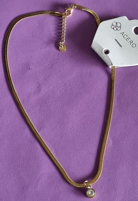 Colar dourado, em aço, malha fita com ponto de luz. Tem extensor