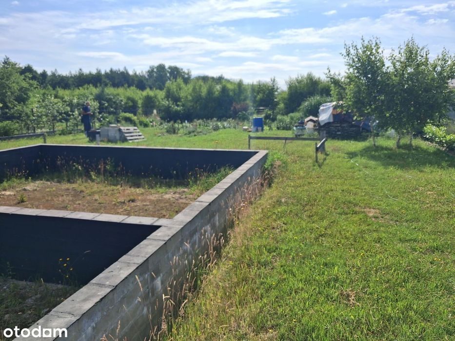 Działka budowlana z rozpoczętą budową z mediami blisko lasu i jeziora.