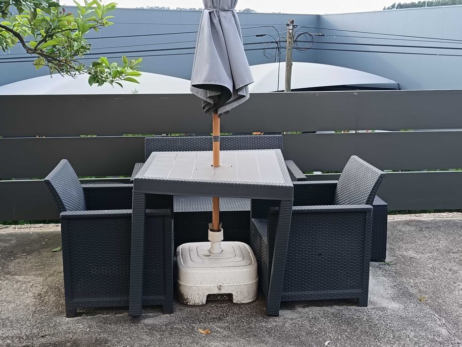 Mesa de jardim com duas cadeiras individuais e uma de dois lugares, guarda sol com a base incluído.
