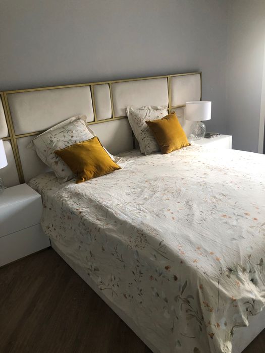 Cama com estrado elevatorio e cabeceira bege e friso dourado