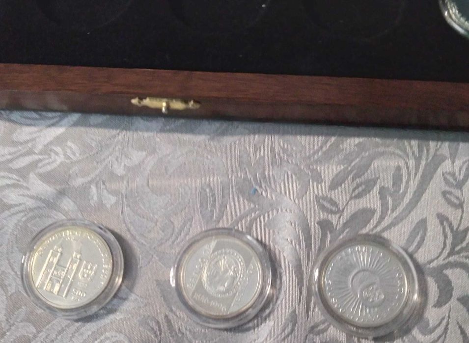 Coleção de sete moedas em pratas, com caixa em madeira