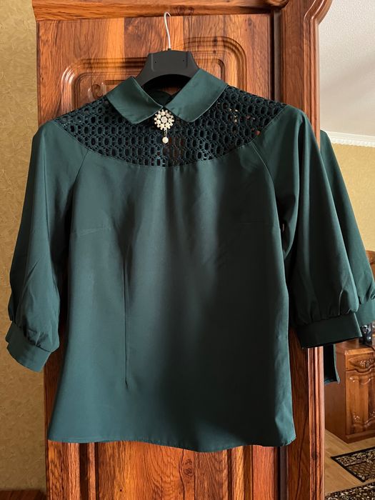 Смарагдова блуза з мереживом і брошкою