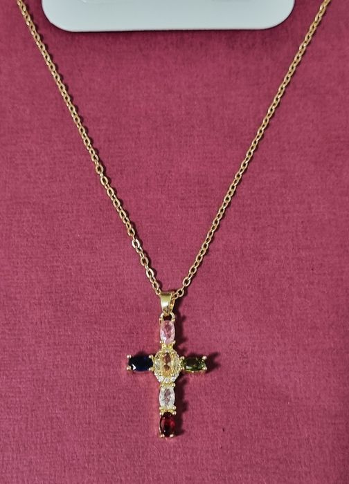 Colar dourado, em aço, com cruz colorida. Tem extensor