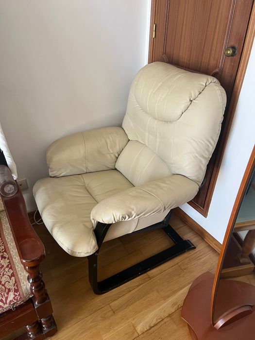 Poltrona em pele creme com base flexível em madeira