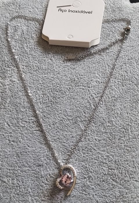 Colar prateado, em aço, com coração e cubo rosinha no centro. Extensor
