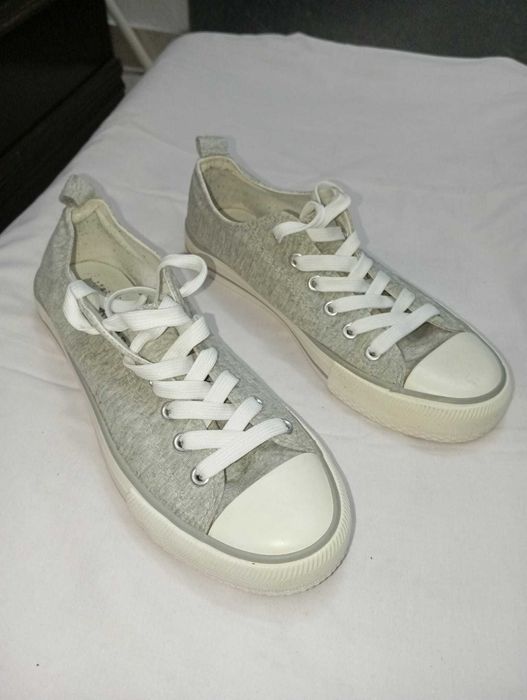 Sapatilhas cizentas, com atacadores brancos