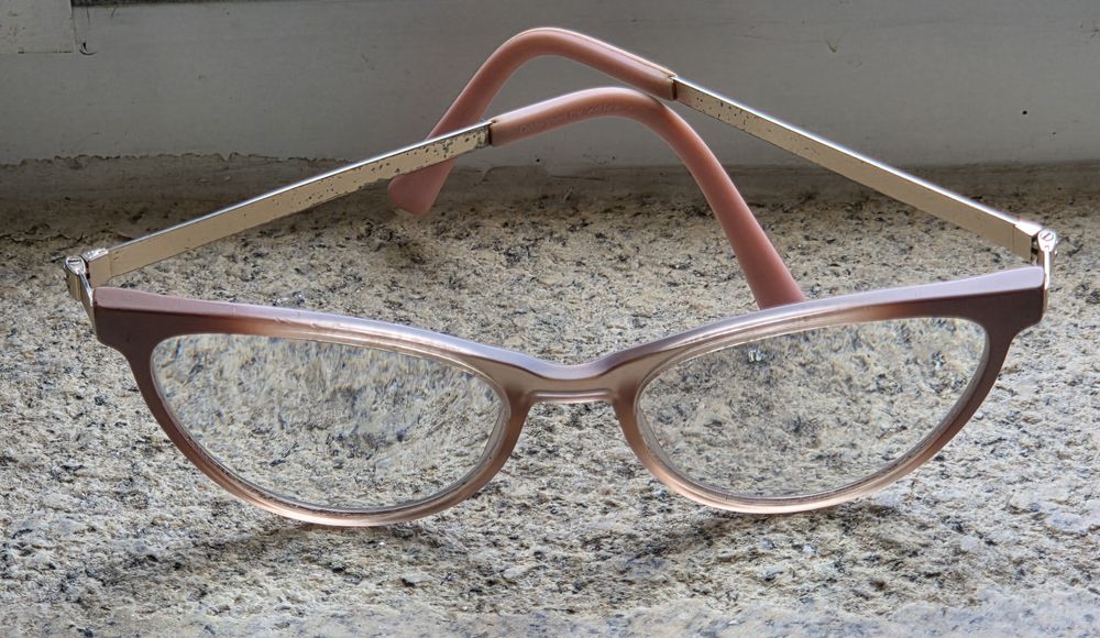 Armação de óculos com aplicativo de lentes escuras que se fixa por íman à armação Tem lentes graduadas que terão que ser lsubstituidas.