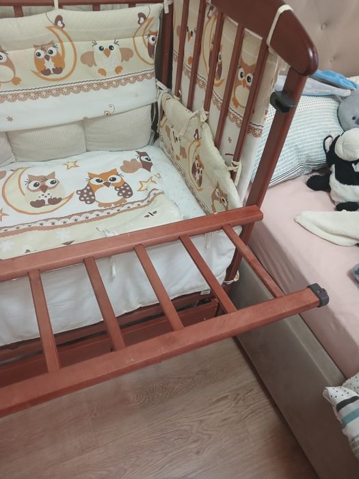 Дитяче ліжечко на маятнику з шухлядою, бортиками і постільною білизною