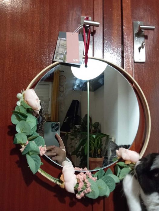 Espelho Atmosphera, aro em madeira clara, rosas e folhas verdes.