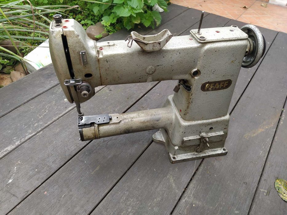 Uma máquina de braço Singer para coser pele e tecidos grossos .