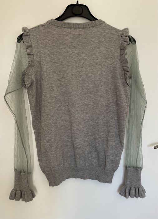 Camisola cinzenta com folhos e manga transparente