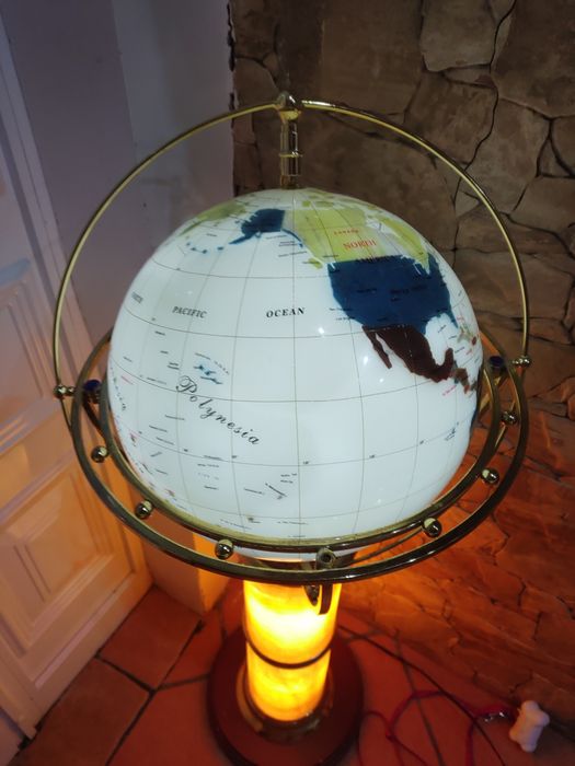 Globo com o mapa do mundo com estrutura em pedra e com base de madeira