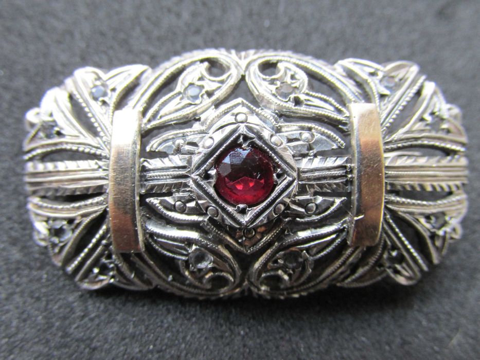 Pregadeira, prata contrastada e ouro, com pedra vermelha e marcassitas