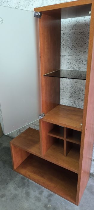 Belíssimo móvel estante em madeira com prateleira e porta em vidro.
Ex