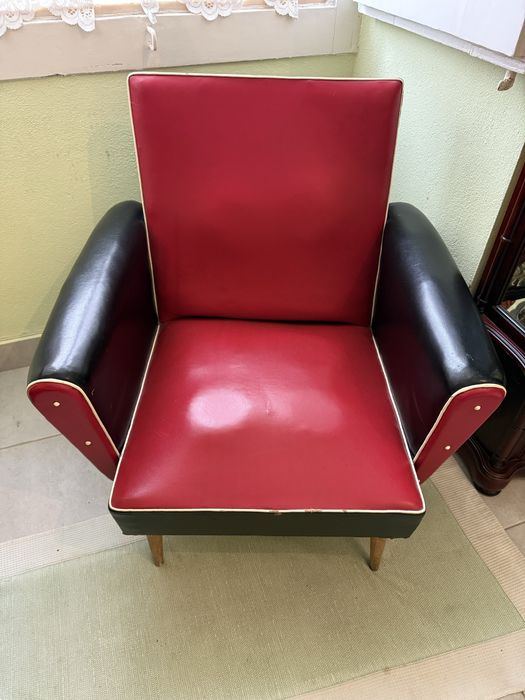 Cadeira de braços vintage em couro vermelho e preto.