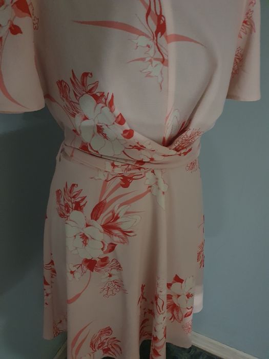 Różowa sukienka w kwiaty wiązana w pasie