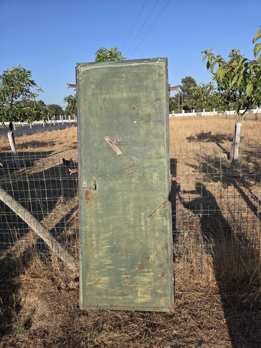 Porta em ferro com aro de fixação.