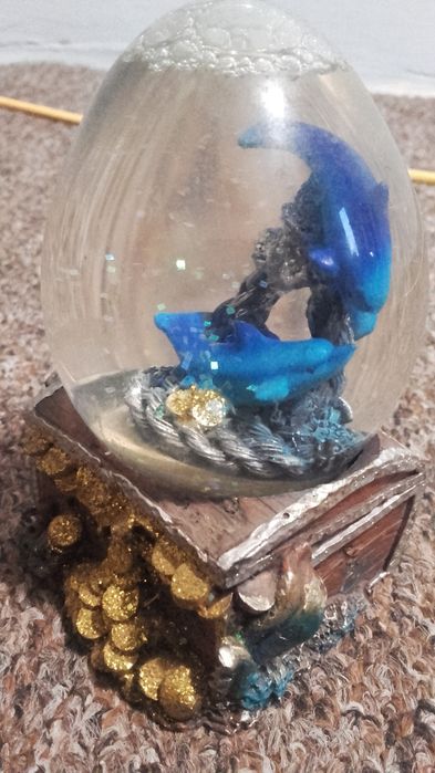 Ozdobna figurka delfiny w kuli wodnej na skrzyni skarbów trójwymiarowy