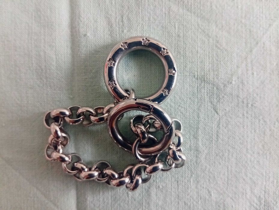 Pulseira em metal prateado, com aros e 2 argolas