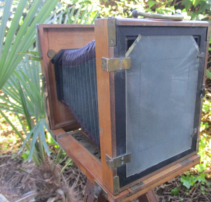 Máquina fotográfica muito antiga de madeira com fole