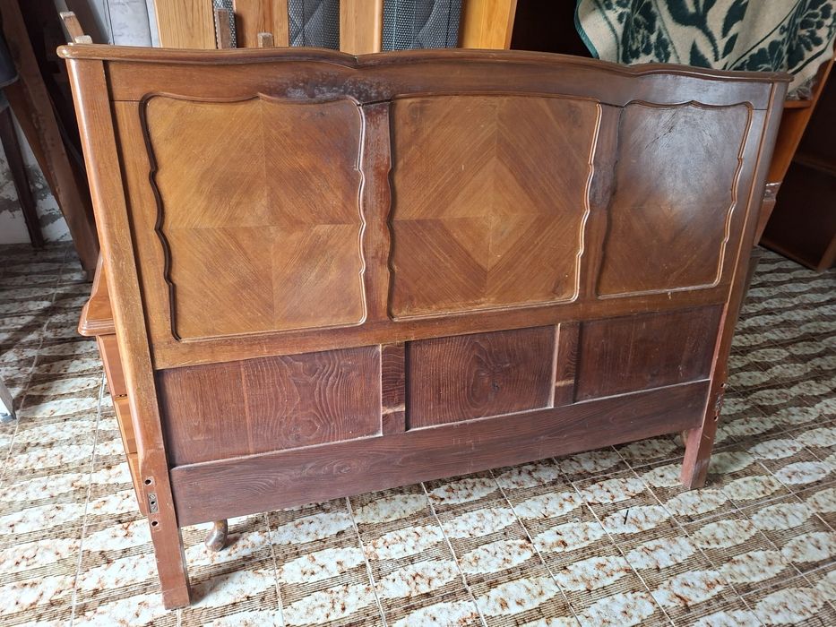 Cama antiga com duas mesinhas de cabeceira.